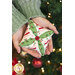 A model holds one of the completed ornaments, demonstrating ribbon, fabric, and button details.