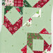 Fabric panel example featuring festive patterns in green, red, and white designed for quilting.