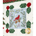 A quilt block featuring a cardinal on branches with leaves and berries, surrounded by a decorative border.