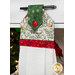 A decorative kitchen towel with a green, snowflake-patterned top and a red band, hanging from a drawer handle.