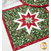 A vibrant green and red quilted hot pad featuring a star pattern with fabric featuring leaves and pinecones.