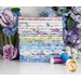 A stack of the fabrics included in Daydreams FQ set, with flowers and thread.