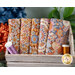A stack of the Caramel and Thristle Wallflower 5 FQ set with thread and a wooden box and flowers