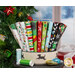 A stack of fabrics featured in the Merry Woof-Mas FQ set, with a dog bowl and a christmas tree and ornaments and presents and thread.