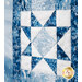 Close-up of a blue and white quilt square featuring a star pattern and snowflake designs.