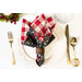 A top down shot of a place setting with the black floral fabric of the napkin faced out.