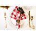 A top down shot of a place setting with the red gingham fabric of the napkin faced out.