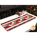 A shot of the full completed table runner staged on a white table surrounded by coordinating tableware, cloth napkins, and a decorated Christmas tree.