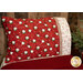 An angled shot of the completed red pillowcase, staged with a small decorative pine tree.