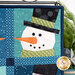 A close up on the upper right snowman, demonstrating fabric, piecing, laser shape, and top stitching details.