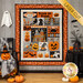 The completed Vintage Haunt BOM quilt, colored in vibrant orange, gray, black, and slate fabrics from the Pumpkins and Potions collection, hung on a gray paneled wall and staged with coordinating Halloween decor.