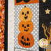 A super close up on the stacked jack o'lantern blocks, demonstrating fabric, applique, top stitching, and top quilting details.