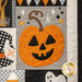 A super close up on a sparkling jack o'lantern block, demonstrating fabric, applique, top stitching, and top quilting details.