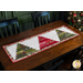 The completed Tree Farm Table Runner in Pine Valley fabrics, staged on a rustic wood table beside a decorated Christmas tree.