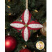 A head on shot of one of the ornaments, colored in olive, scarlet, and white fabrics, staged on a Christmas tree.