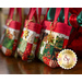 Three overlapping tiny tote bags with red straps, patchwork, and decorative golden charms, displayed on a table.