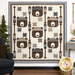 The completed Cozy Paddling Bears Quilt in soft cream, brown, and blue fabrics from the Farmhouse Flannels III collection by Moda, hung on a white paneled wall and staged with coordinating woodsy decor.