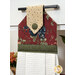 Decorative kitchen towel hanging from a drawer handle, featuring floral patterns and a polka dot top.