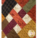 Close-up of a colorful patchwork quilt demonstrating fabric and top quilting details.