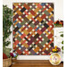 Colorful quilt featuring a patchwork design with rich earth tones, displayed in a cozy room setting.