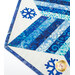 Up close of blue and white snowflake table topper demonstrating fabric and top quilting details.