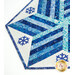 Close-up of a blue and white quilted table runner featuring a snowflake design and geometric patterns.