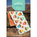 A vibrant table runner featuring acorn and geometric patterns, displayed against a scenic backdrop.