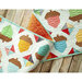 Colorful quilt featuring acorns and geometric shapes on a textured background, laid on wooden surface.