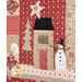 An angled close up on a snowman and house block, demonstrating fabric, applique, piecing, embellishment, and top quilting details.