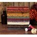 A stack of the fabrics in tje Where the Wind Blows collection, with flowers and a vase and thread.
