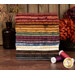 A stack of the fabrics in tje Where the Wind Blows collection, with flowers and a vase and thread.