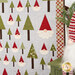 A close up on the right edge of the quilt, demonstrating fabric, laser shape, border, and binding details. A holiday gnome and coordinating decor sit on a green counter on the right edge of the frame.