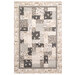 A patterned quilt featuring a patchwork design with beige, gray, and cream fabrics isolated on a white background.