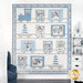 The completed Snow Train quilt, colored in white, gray, and light and dark blue flannels from the Snow Much Fun collection. Hung on a white paneled wall, the quilt is staged with coordinating winter themed decor and furniture.