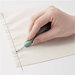 A hand holds a seam ripper, carefully unstitching a line of thread on a piece of fabric.