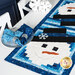 An angled shot of the snowman runner on a table set with plates, tableware, fabric napkins, wine glasses, and winter decor, demonstrating usage.