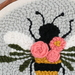 A super close up on the Bloomin Bee project, showing fine details on the yarn bee and flowers.