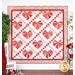 A quilt featuring large red, white and pink valentine hearts arranged in an Irish chain grid against a white background with floral borders.