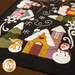 An angled shot of one end of the runner, demonstrating fabric and piecing details on the snowmen and houses.