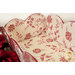 Red and cream floral fabric lined basket with scalloped edges, surrounded by red roses