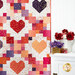 A closer look at the Heartsy quilt, showing piecing and fabric details. Coordinating flowers and decor make the colors and prints pop.