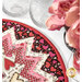 Valentine-themed table topper with heart patterns, alongside pink roses in a black vase and glassware.