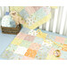 A colorful changing mat in pastel shades with animal patterns sits on a crib, accompanied by stuffed toys and bottles.