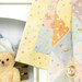 A colorful quilt with polka dots hangs near a teddy bear on a shelf.