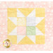 A pastel quilt square featuring a star pattern in yellow, pink, and green on a pink polka dot background.