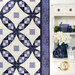 A quilt featuring a geometric design in shades of blue and white hangs next to a white shelf with decor.