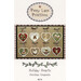 The front of the Holiday Hearts pattern featuring the finished ornaments displayed on a wool background.