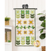 The completed Feeling Lucky door banner, colored in cream, green, and golden yellow fabrics, hung on a white wall from a craft hanger and staged with coordinating decor.