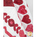 Close-up of a red and white quilt featuring patchwork hearts and shapes.