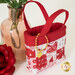 One of the Tiny Tote Bags, staged with roses, demonstrating fabric, lace trim, and gold heart charm details.